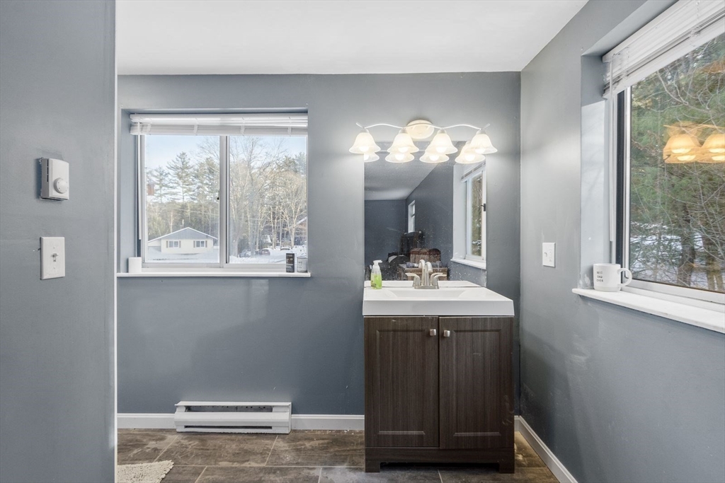 60 Stone Valley Road Orange, MA 01364 - Photo 15 of 27 a bathroom with a granite countertop sink a large mirror and a window