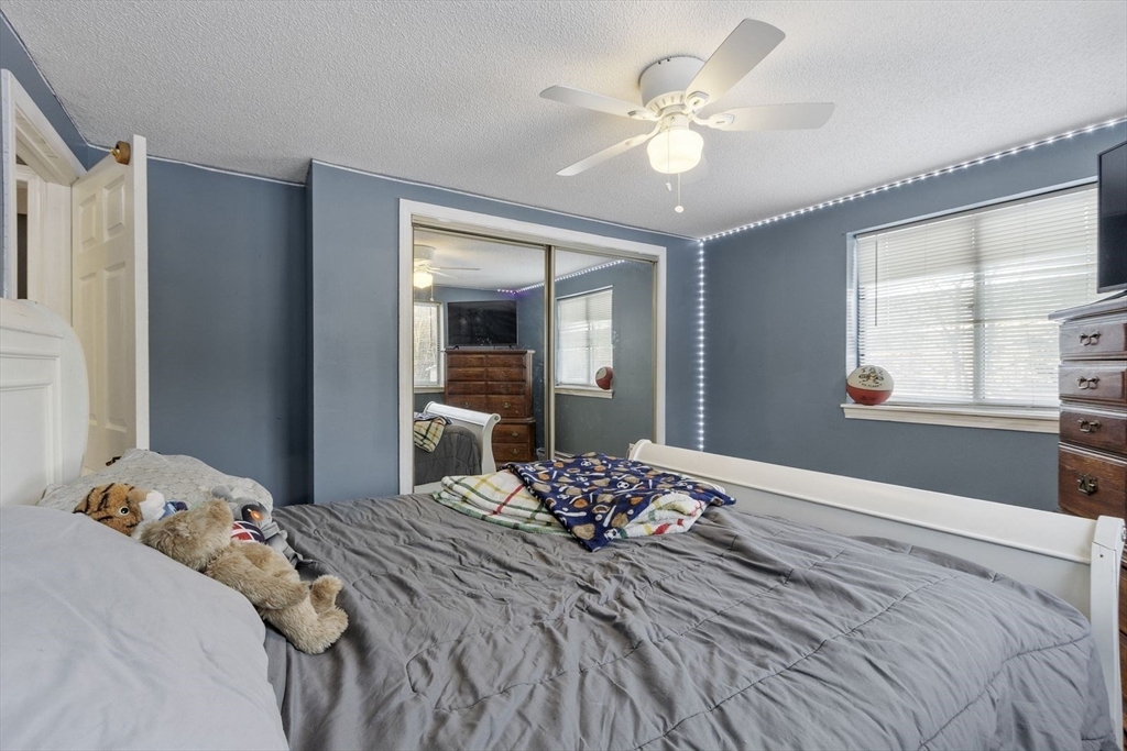 60 Stone Valley Road Orange, MA 01364 - Photo 21 of 27 a bedroom with a large bed and a chandelier