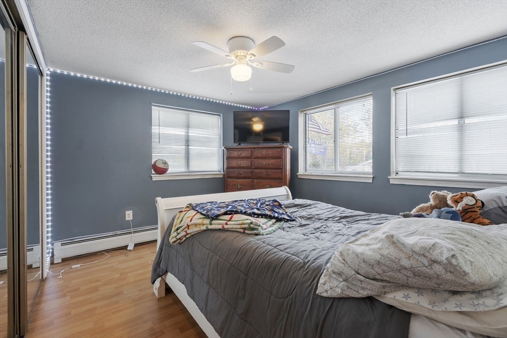 60 Stone Valley Road Orange, MA 01364 - Photo 23 of 27 a bedroom with a bed and a window with a chandelier