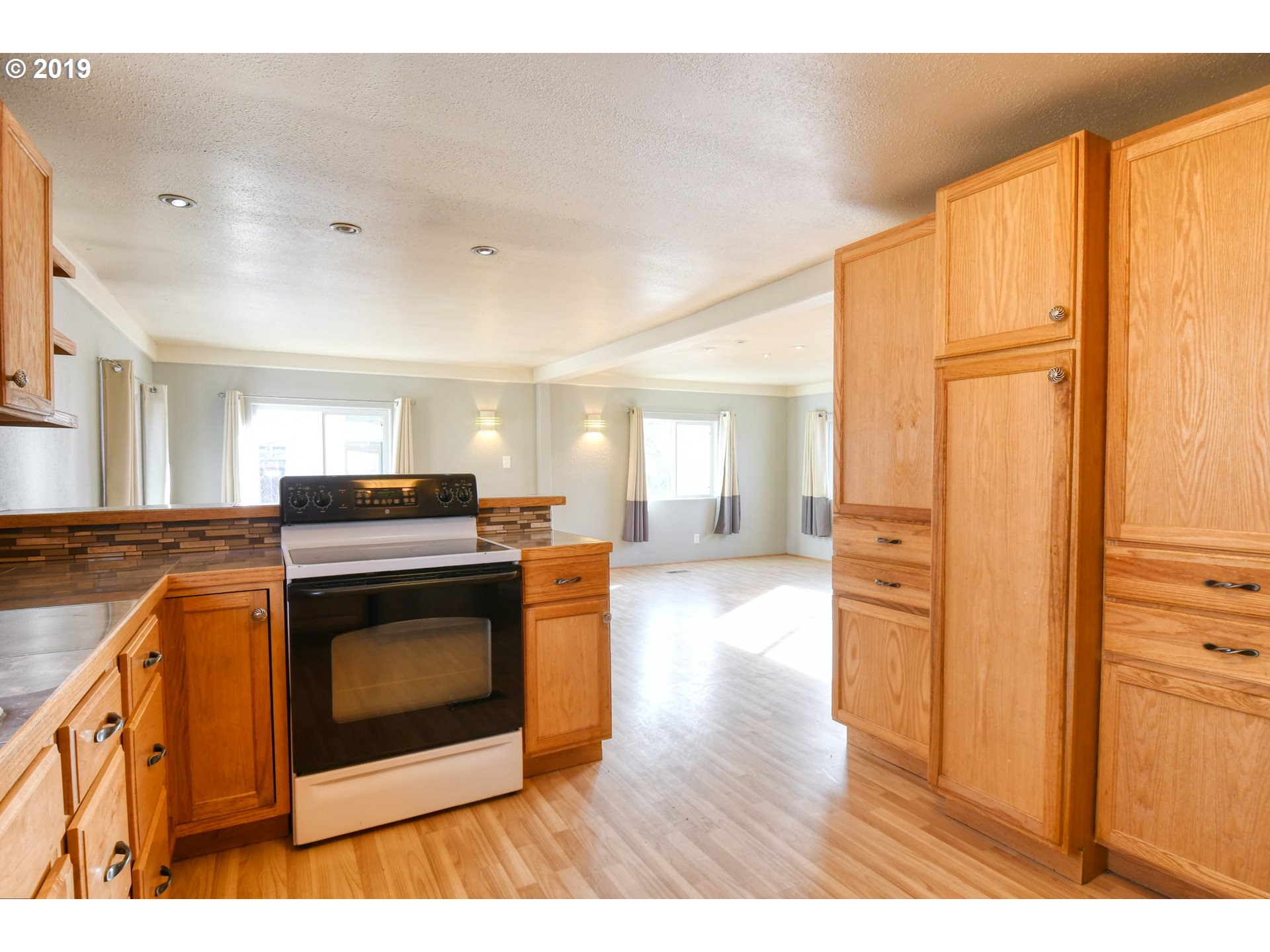 2811 Northeast Riverside Avenue Pendleton, OR 97801 - Photo 7 of 32 a kitchen with stainless steel appliances granite countertop a stove a sink and a refrigerator with wooden floor
