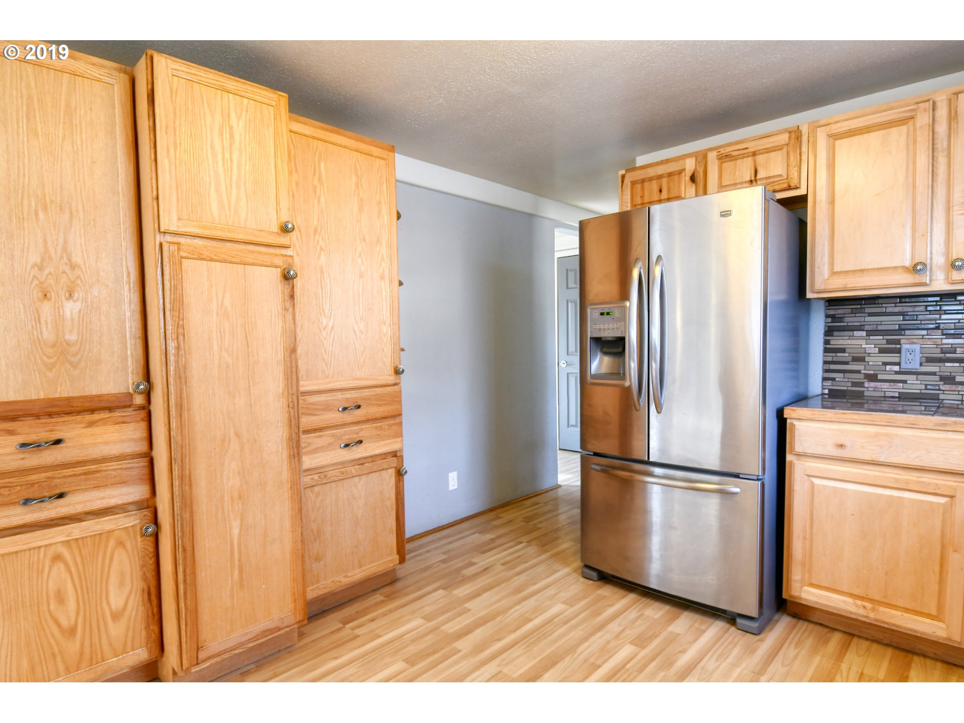 2811 Northeast Riverside Avenue Pendleton, OR 97801 - Photo 10 of 32 a kitchen with stainless steel appliances wooden floor and a window