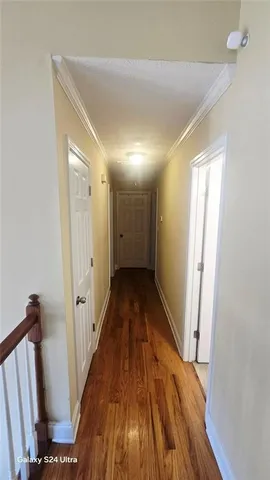 a view of a hallway with wooden floor and staircase