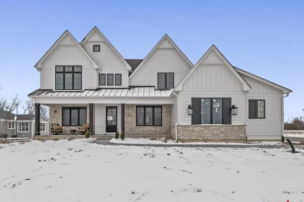 a front view of a house with a yard covered in snow