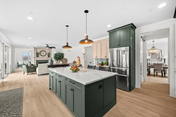 a kitchen with stainless steel appliances kitchen island granite countertop a table chairs and a refrigerator