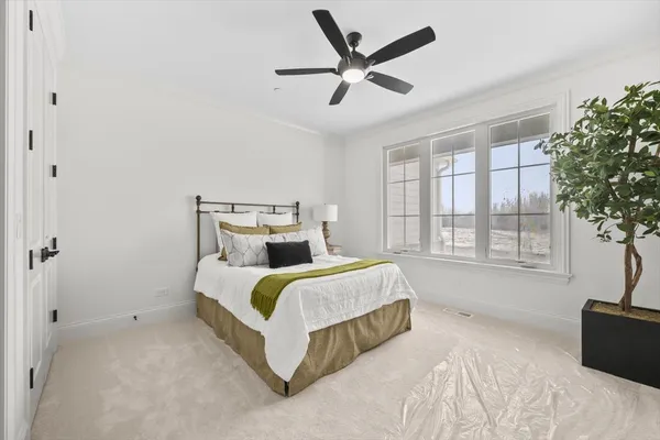 a spacious bedroom with a bed and a large window