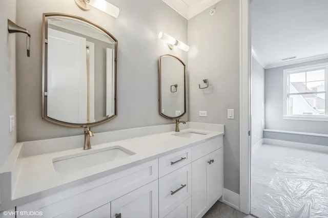 a bathroom with a double vanity sink mirror and bathtub
