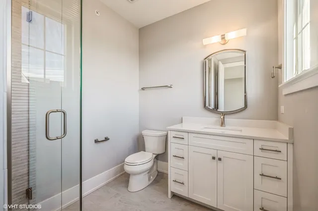 a bathroom with a toilet sink vanity and mirror