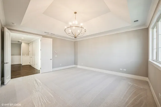 a view of an empty room with a chandelier fan