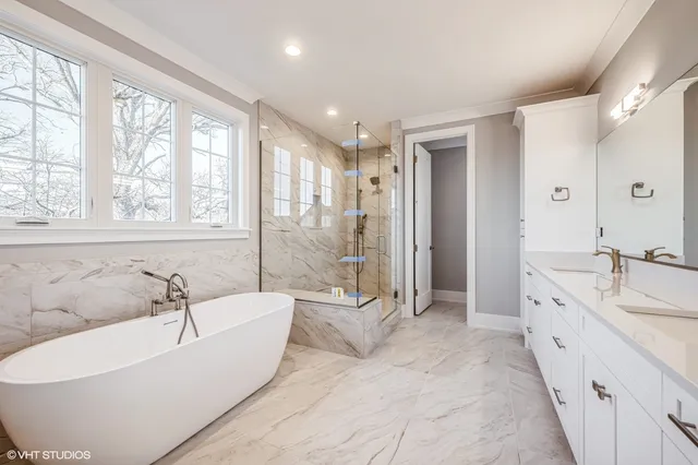 a spacious bathroom with a tub sink shower and mirror