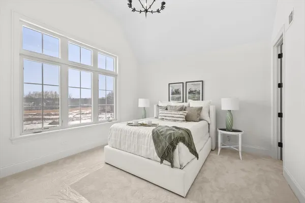 a spacious bedroom with a bed and a large window