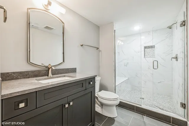 a bathroom with a sink a toilet and shower