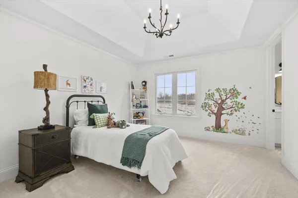 a bedroom with a bed and a chandelier