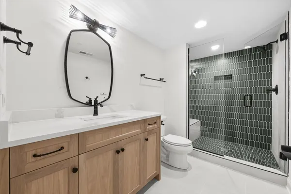 a bathroom with a toilet a sink and mirror