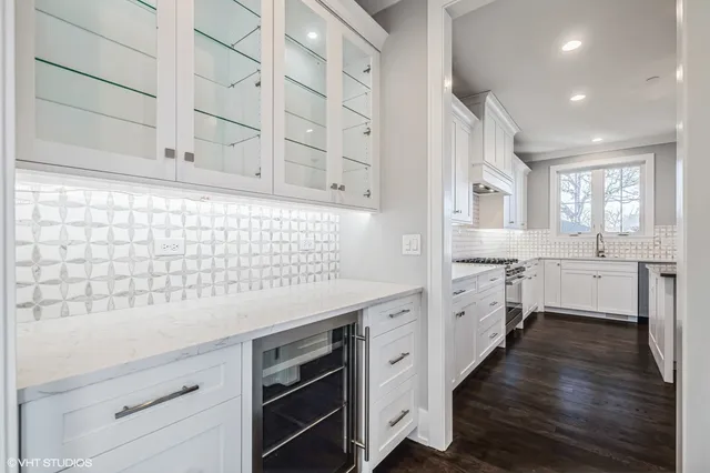 a kitchen with stainless steel appliances white cabinets and wooden floors