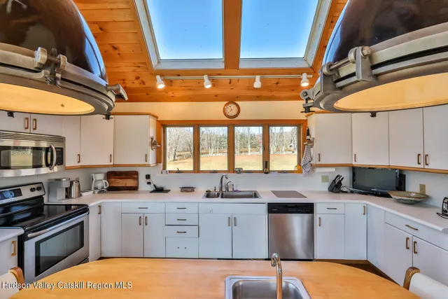 a kitchen with stainless steel appliances granite countertop a sink a stove and refrigerator