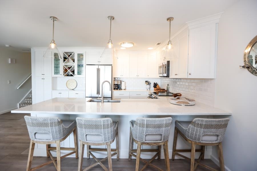 902 Ocean, Unit 906 Cape May, NJ 08204 - Photo 9 of 46 a kitchen with a dining table chairs and cabinets