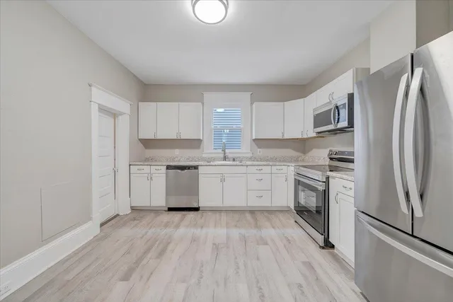 a kitchen with a refrigerator stove top oven and sink