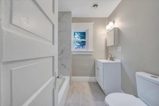 a bathroom with a toilet sink and mirror