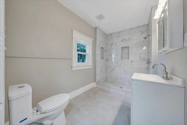 a bathroom with a sink toilet and window