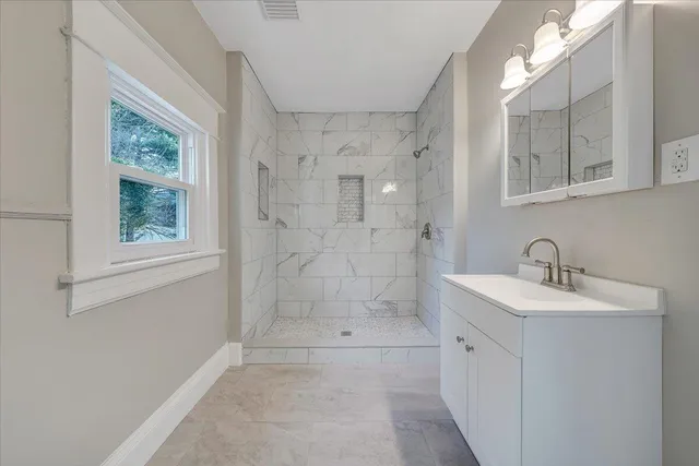 a bathroom with a shower sink and mirror