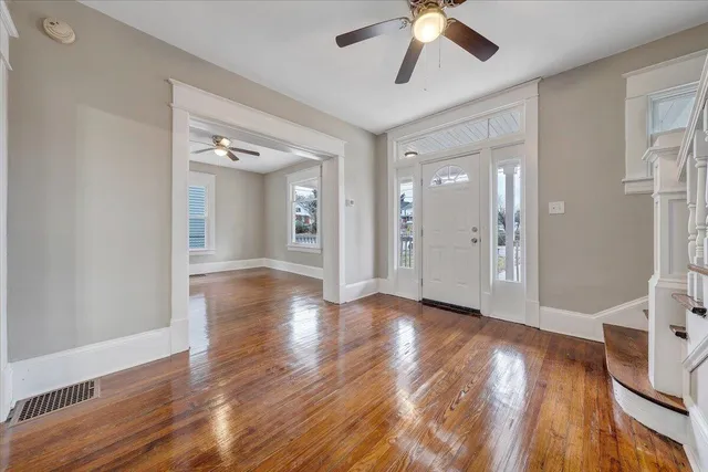 a view of a livingroom with wooden floor and a ceiling fan