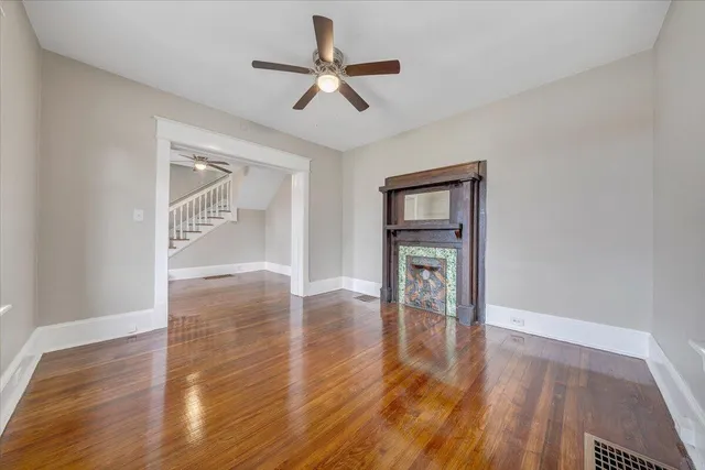 a view of empty room with wooden floor and window