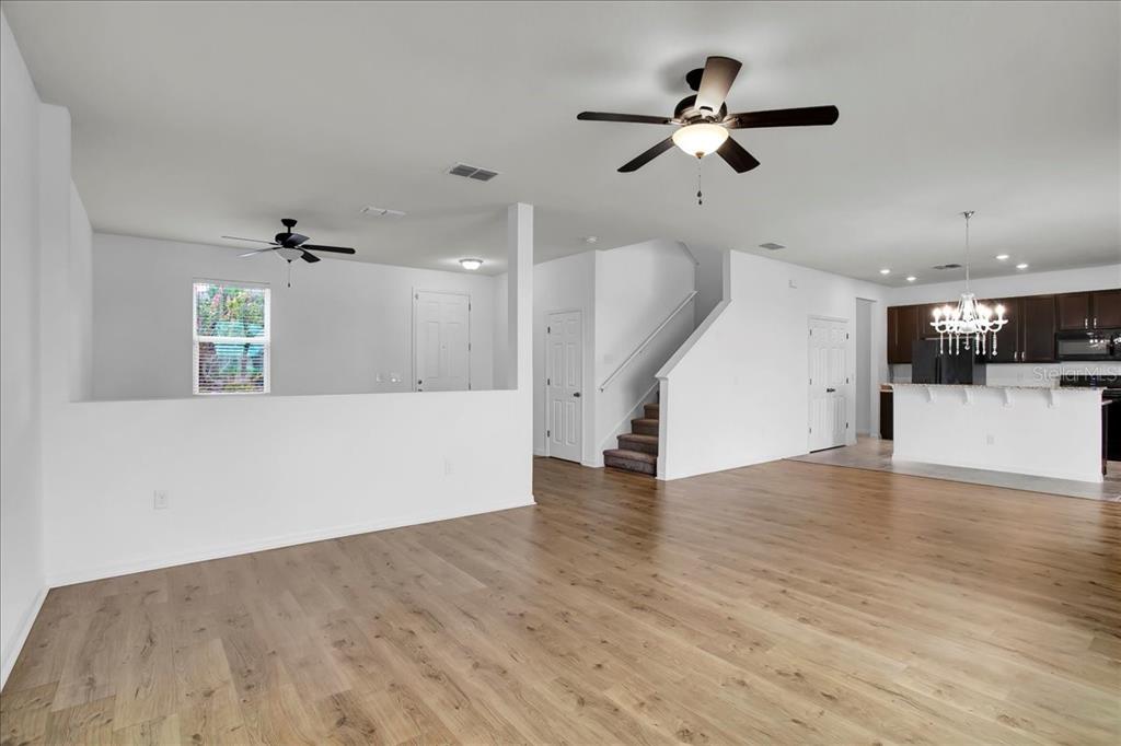 11544 Brighton Knoll Loop Riverview, FL 33579 - Photo 38 of 65 a view of an empty room with wooden floor and a ceiling fan