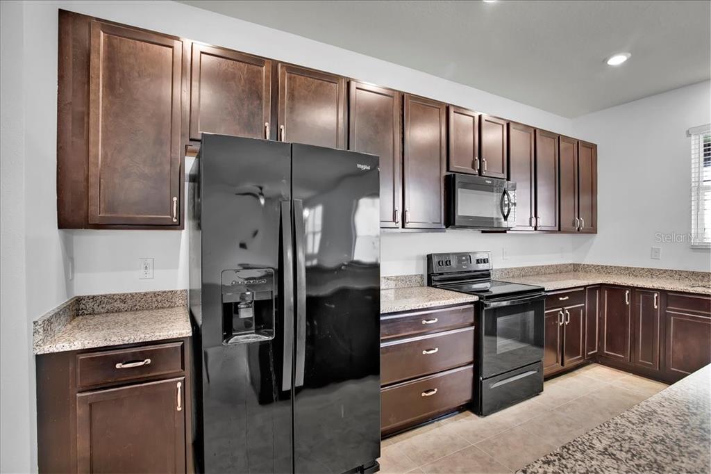 11544 Brighton Knoll Loop Riverview, FL 33579 - Photo 42 of 65 a kitchen with stainless steel appliances granite countertop a refrigerator and a stove top oven