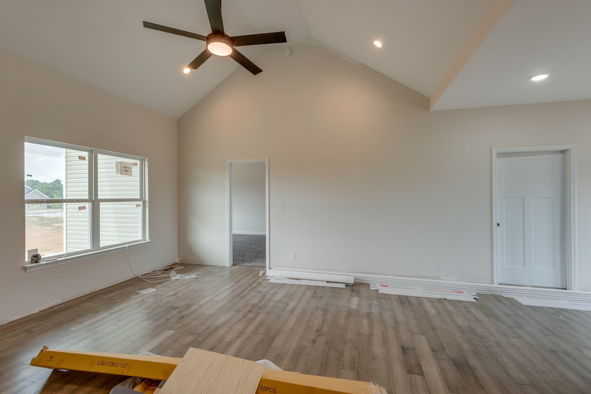 1202 Oak Grove Road Dickson, TN 37055 - Photo 8 of 28 an empty room with wooden floor chandelier fan and windows