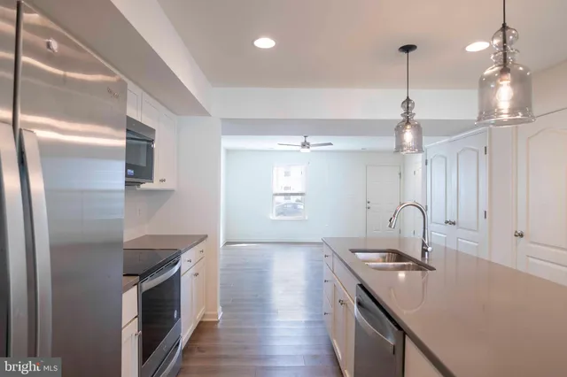 a kitchen with granite countertop a sink and stainless steel appliances