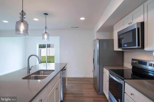 a kitchen with kitchen island granite countertop a sink stainless steel appliances and counter space