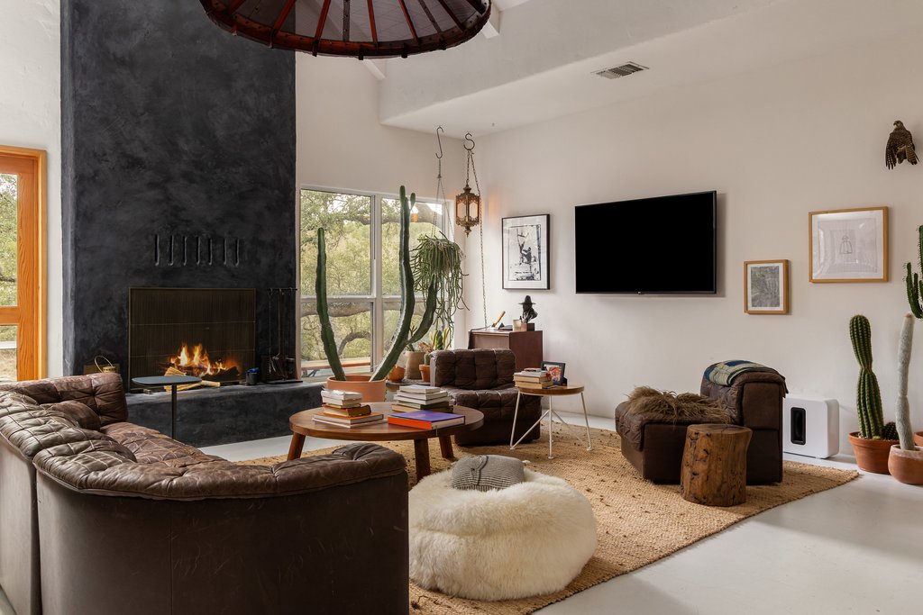 412 Rancho Grande Drive Wimberley, TX 78676 - Photo 2 of 37 Living room featuring a fireplace, high vaulted ceiling, and concrete flooring
