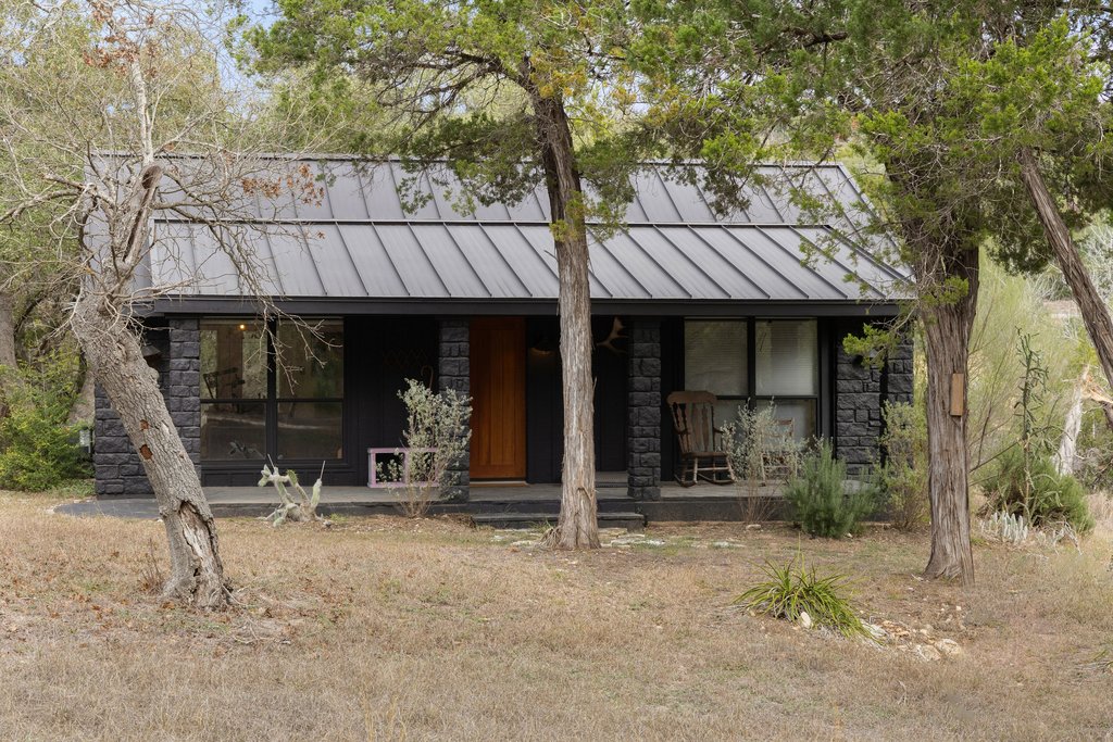 412 Rancho Grande Drive Wimberley, TX 78676 - Photo 21 of 37 View of front of house featuring stone siding, a standing seam roof, and a metal roof