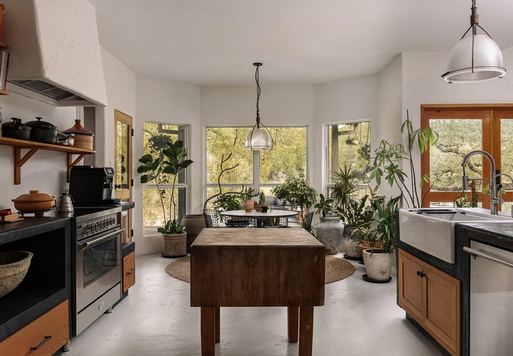 412 Rancho Grande Drive Wimberley, TX 78676 - Photo 5 of 37 Kitchen featuring premium range hood, pendant lighting, stainless steel appliances, and brown cabinetry