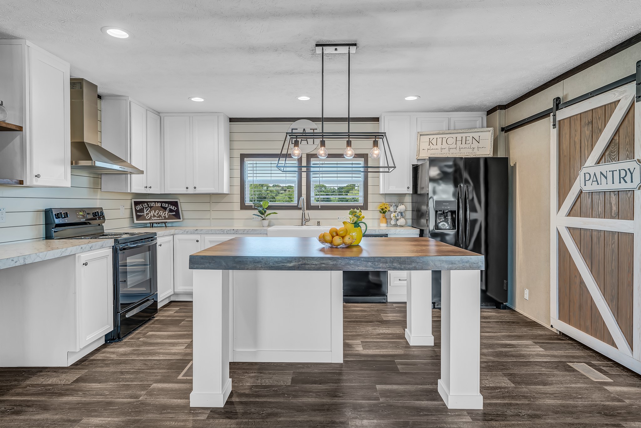 a kitchen with stainless steel appliances granite countertop a table chairs refrigerator and microwave