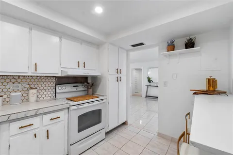 a kitchen with stainless steel appliances white cabinets and a stove top oven