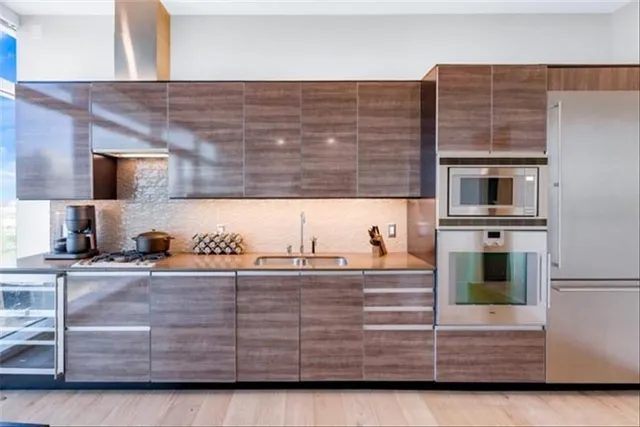 a kitchen with stainless steel appliances kitchen island granite countertop a stove a sink and a microwave