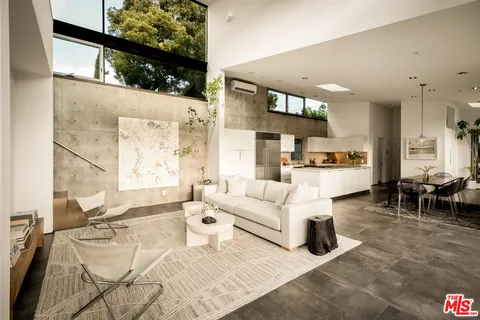 a living room with furniture a dining table and kitchen view