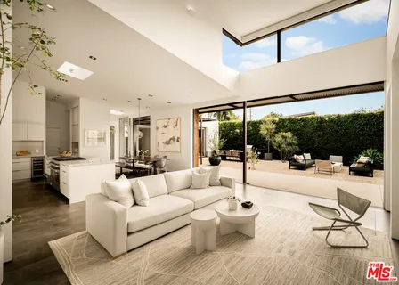 a open kitchen with white cabinets a table and chairs