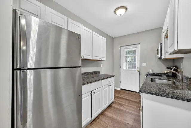 a kitchen with granite countertop a refrigerator and a sink