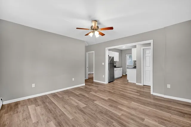 a view of empty room with wooden floor and ceiling fan
