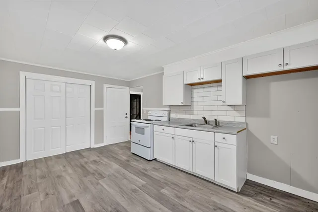 a kitchen with sink cabinets and wooden floor