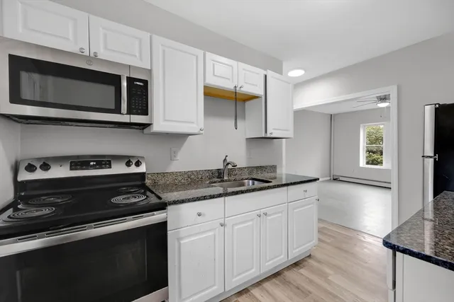 a kitchen with stainless steel appliances granite countertop a stove a microwave and a sink