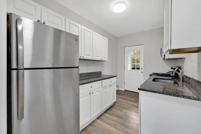 a kitchen with stainless steel appliances granite countertop a refrigerator a sink and a stove