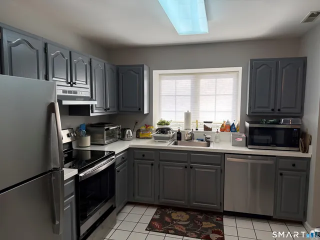 a kitchen with stainless steel appliances granite countertop a refrigerator sink and cabinets