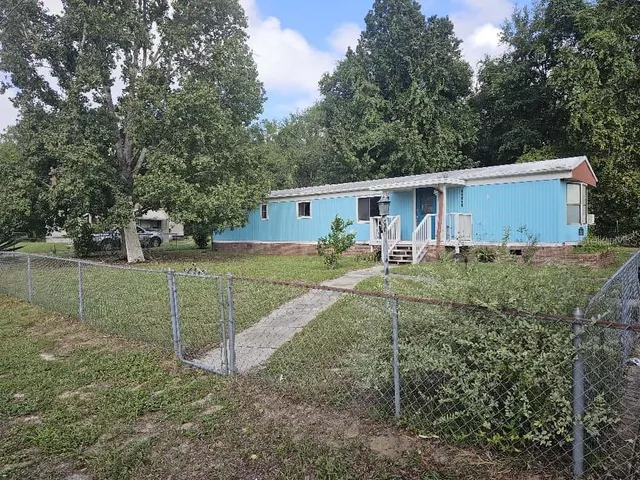 a view of a backyard with wooden fence