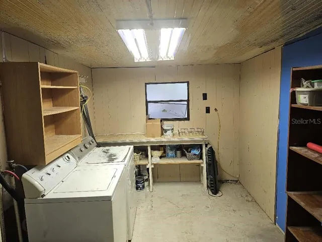 a view of a hallway to room with furniture and window