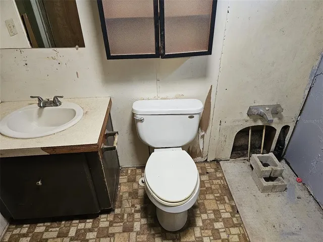a bathroom with a sink toilet and mirror
