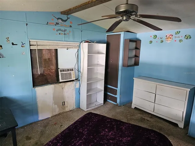 a bedroom with a bed and a refrigerator