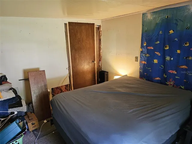 a bedroom with a bed and a painting on the wall